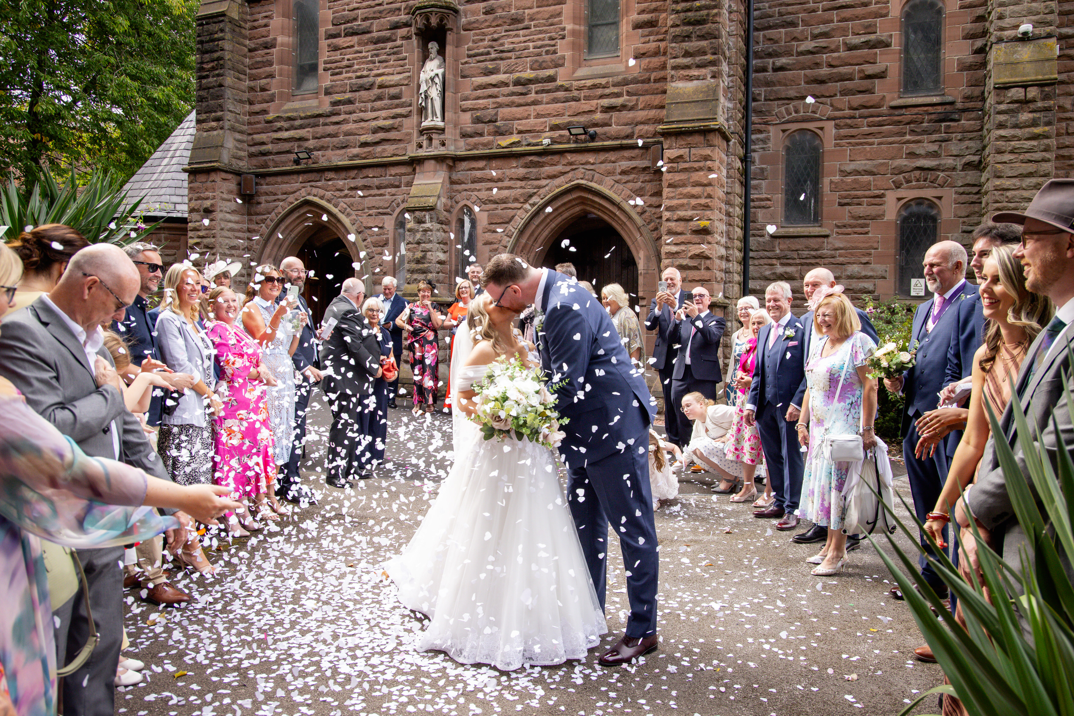 Jeanette and Sean have a kiss as the guests throw confetti over them 