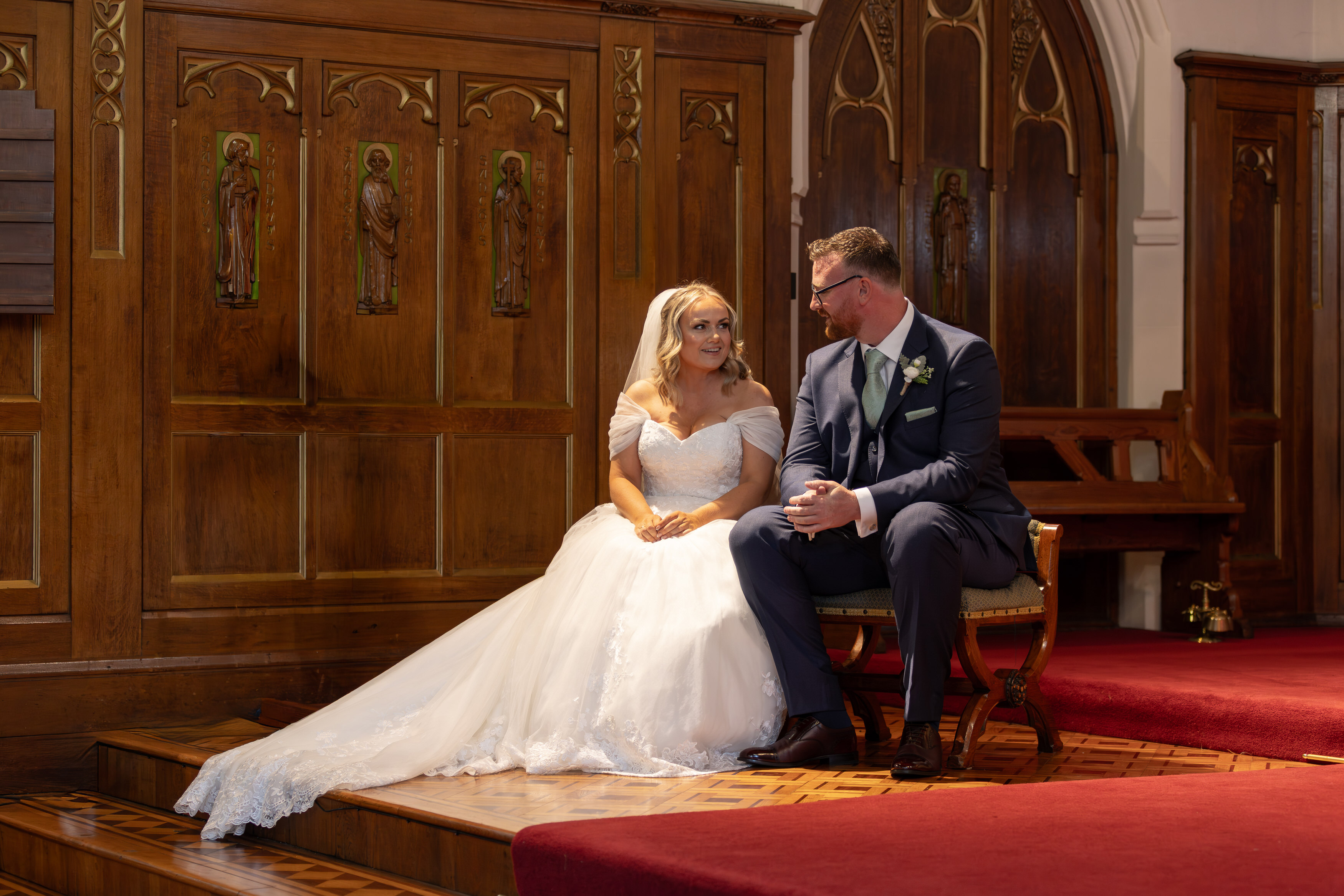 The bride and groom take a seat in the church
