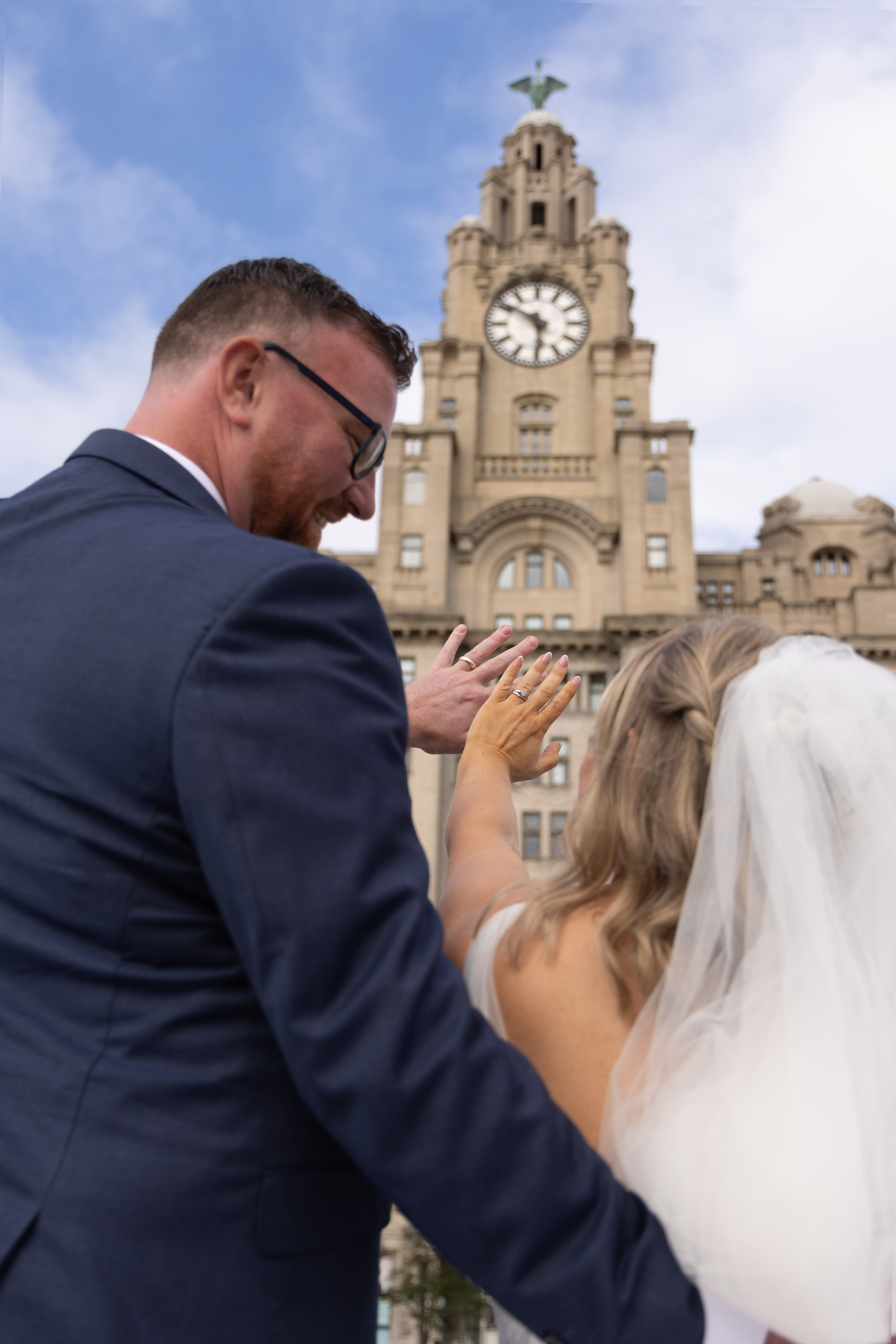 The bride and groom show off their wedding rings 