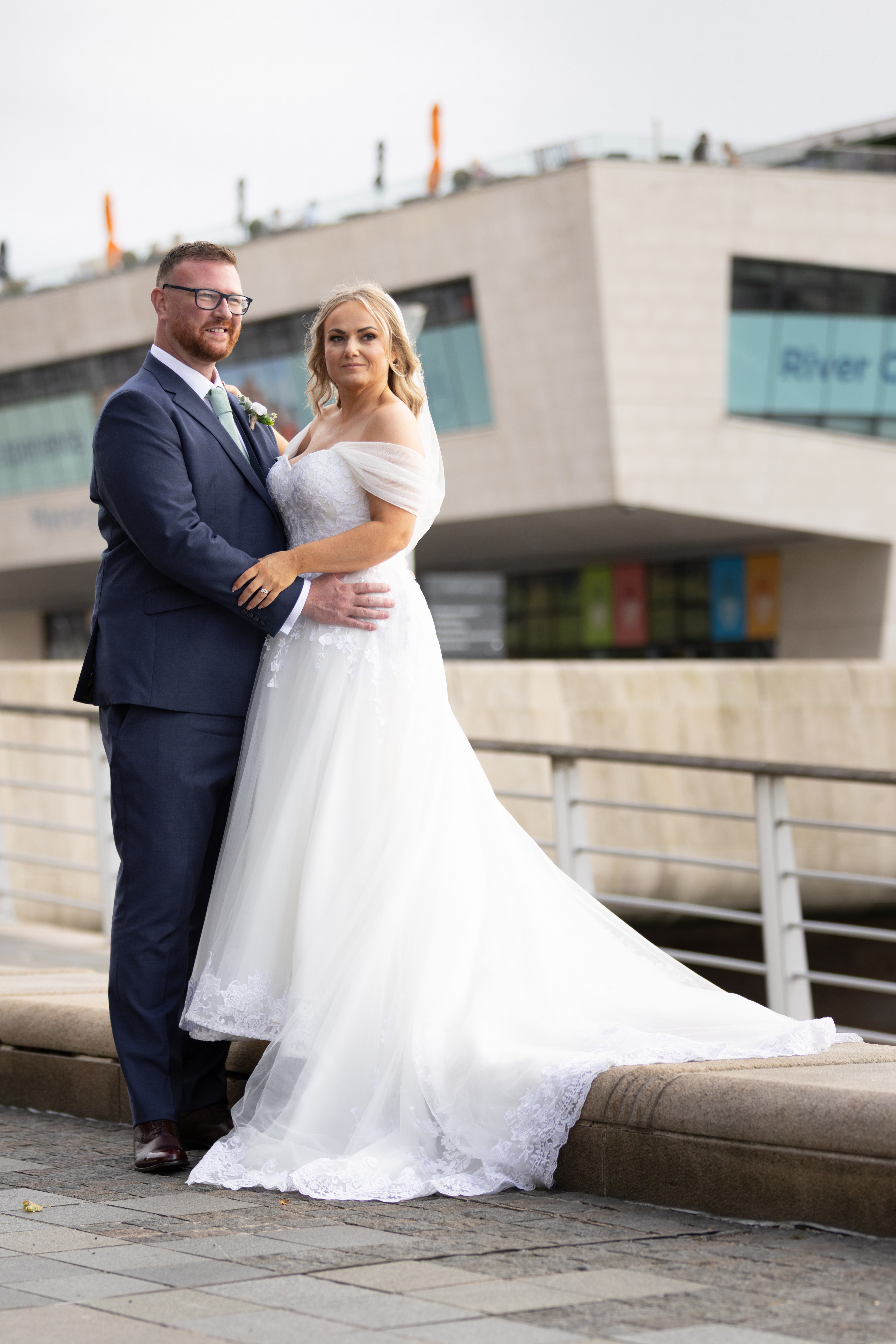 The bride and groom pose for a photo on Liverpool docks 
