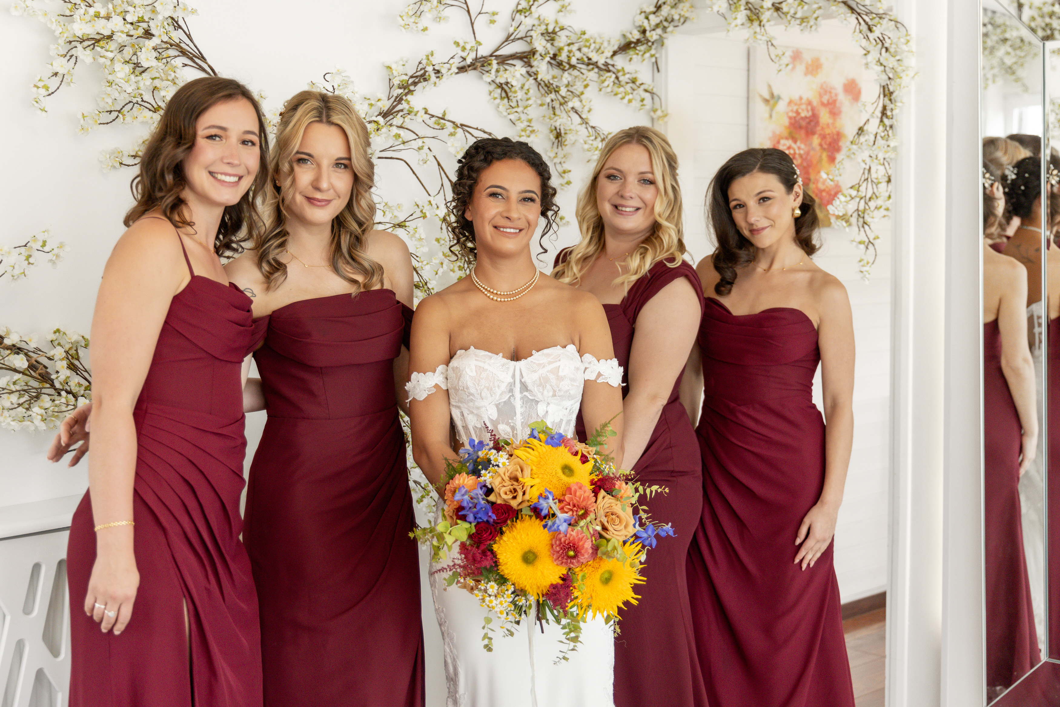The bride and her bridesmaids all looking lovely in their wedding dresses 