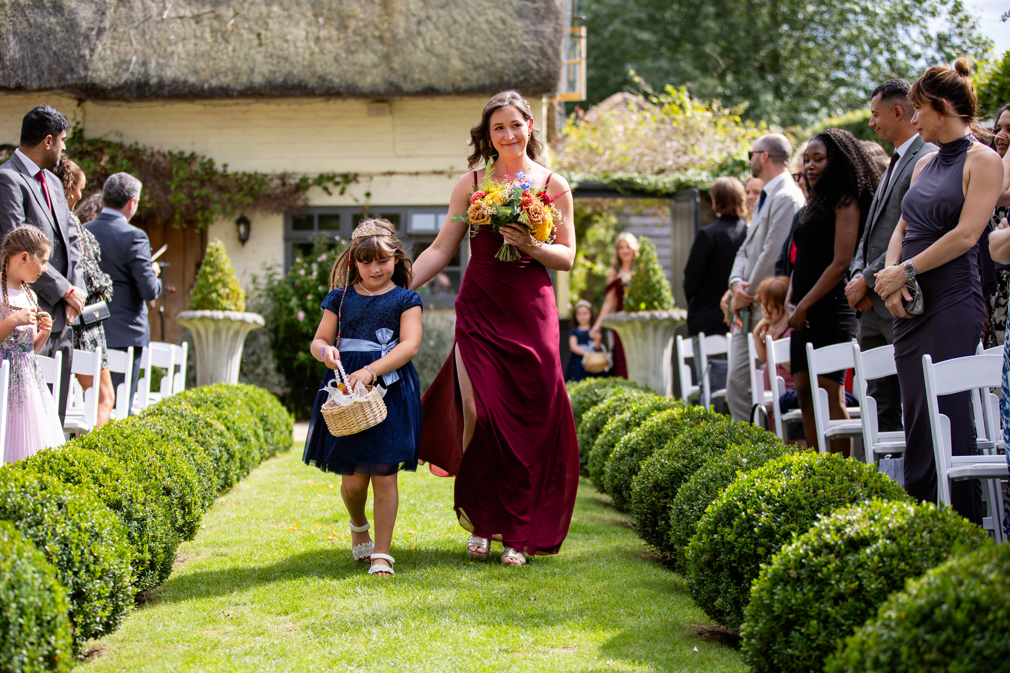 The bridesmaid and flower girl walking down the lawn 
