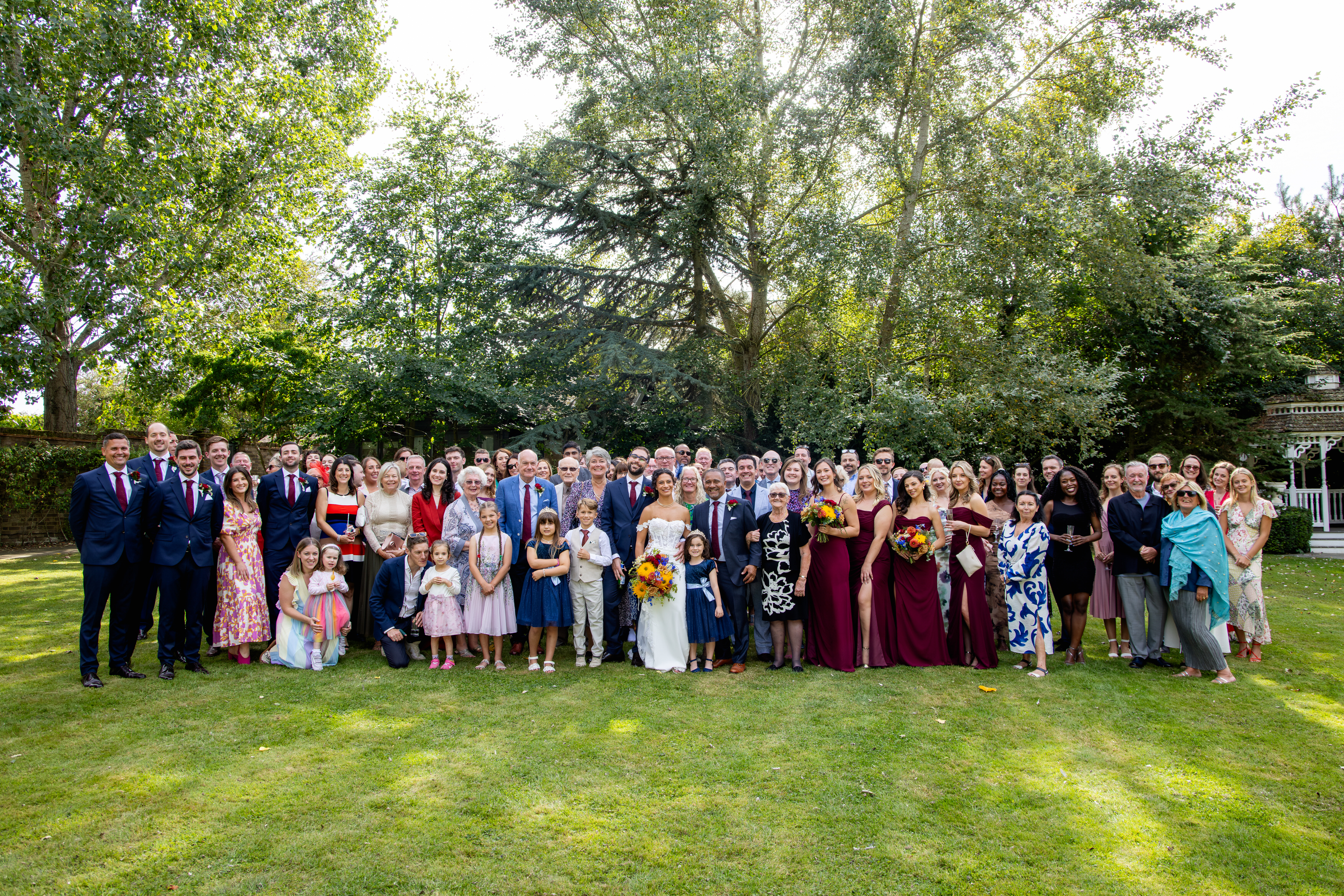 A group photo of the bride and groom with all their wedding guests 