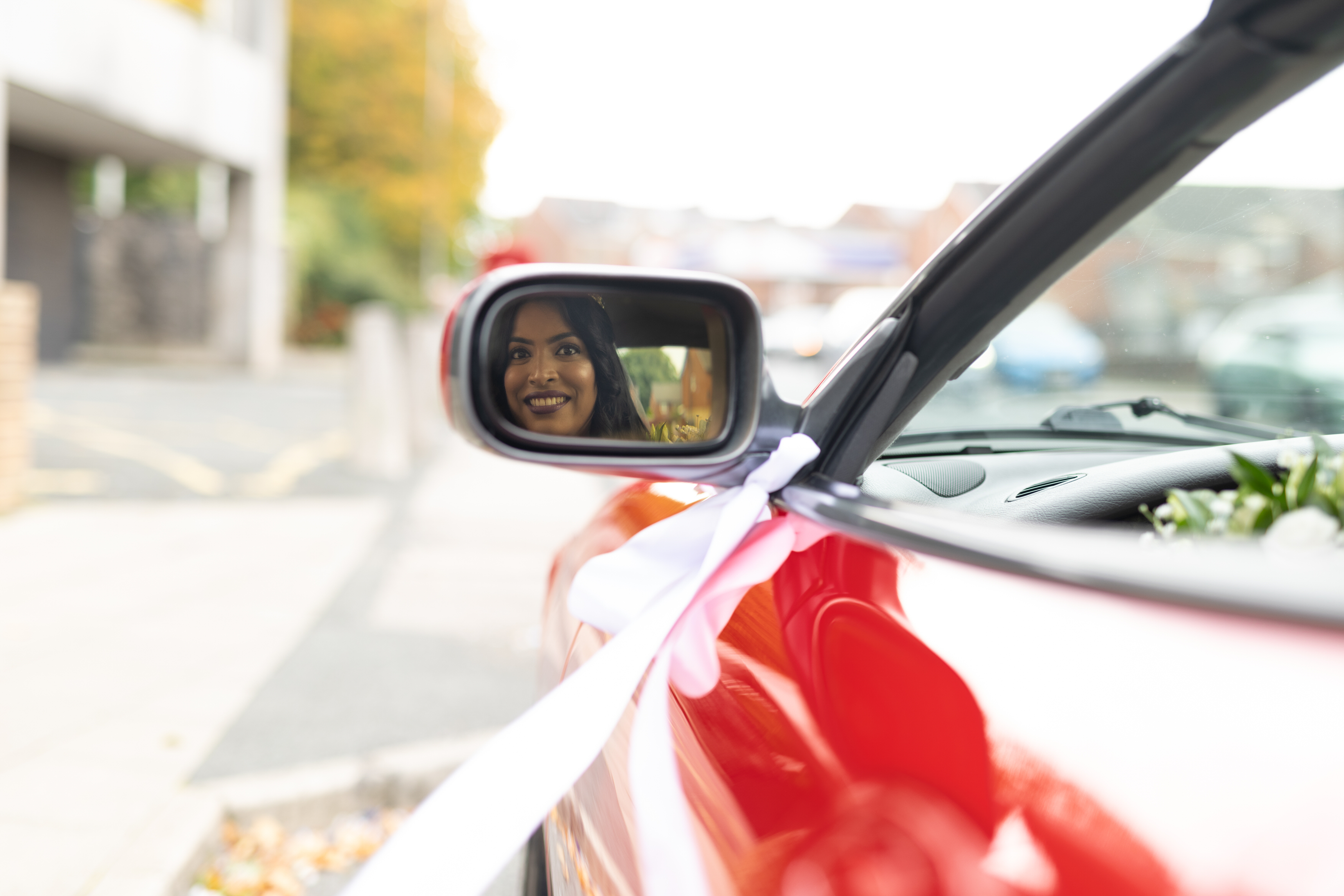 Udara looking back in the mirror in the red Ferrari 