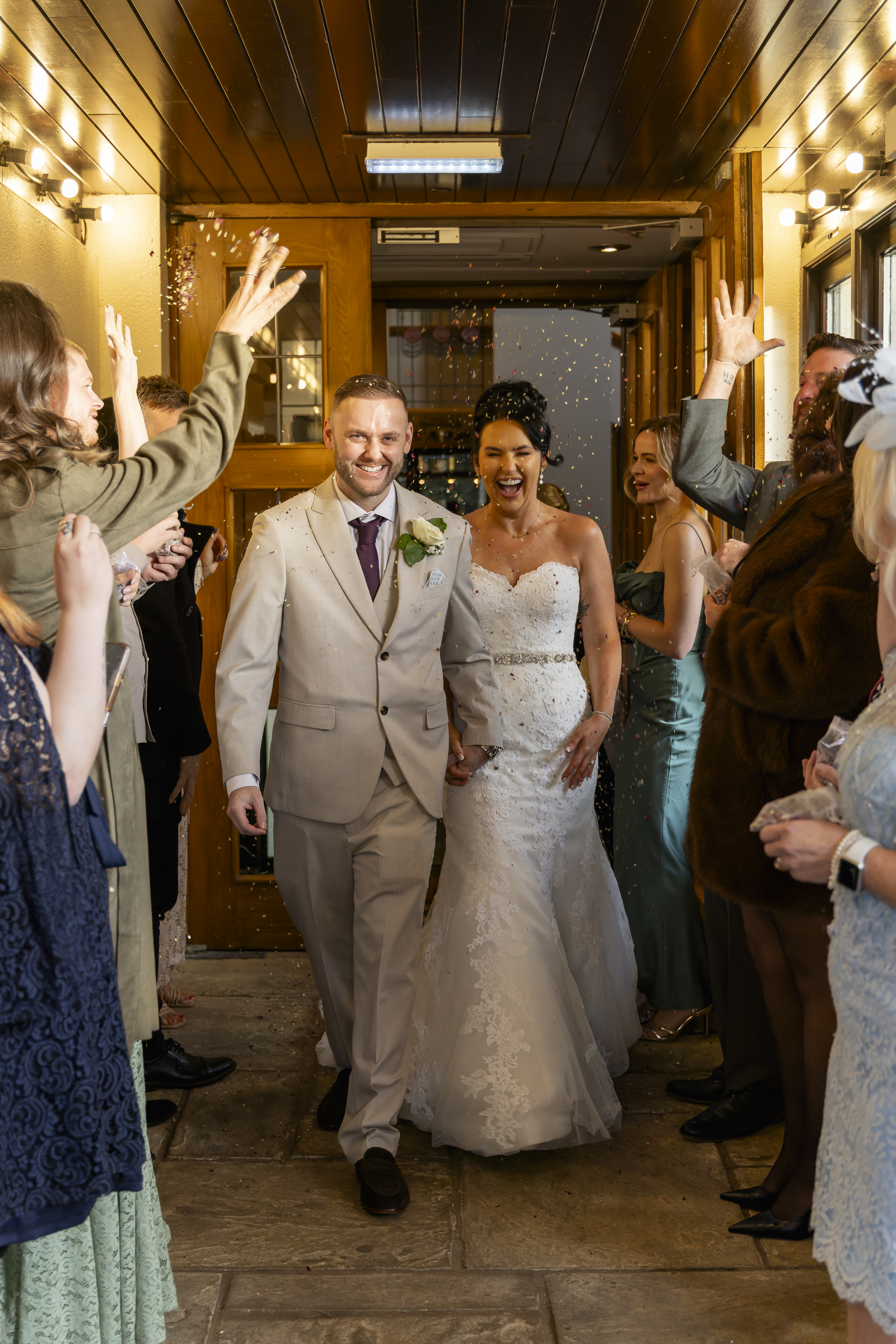The wedding guests get ready to throw confetti over the bride and groom 