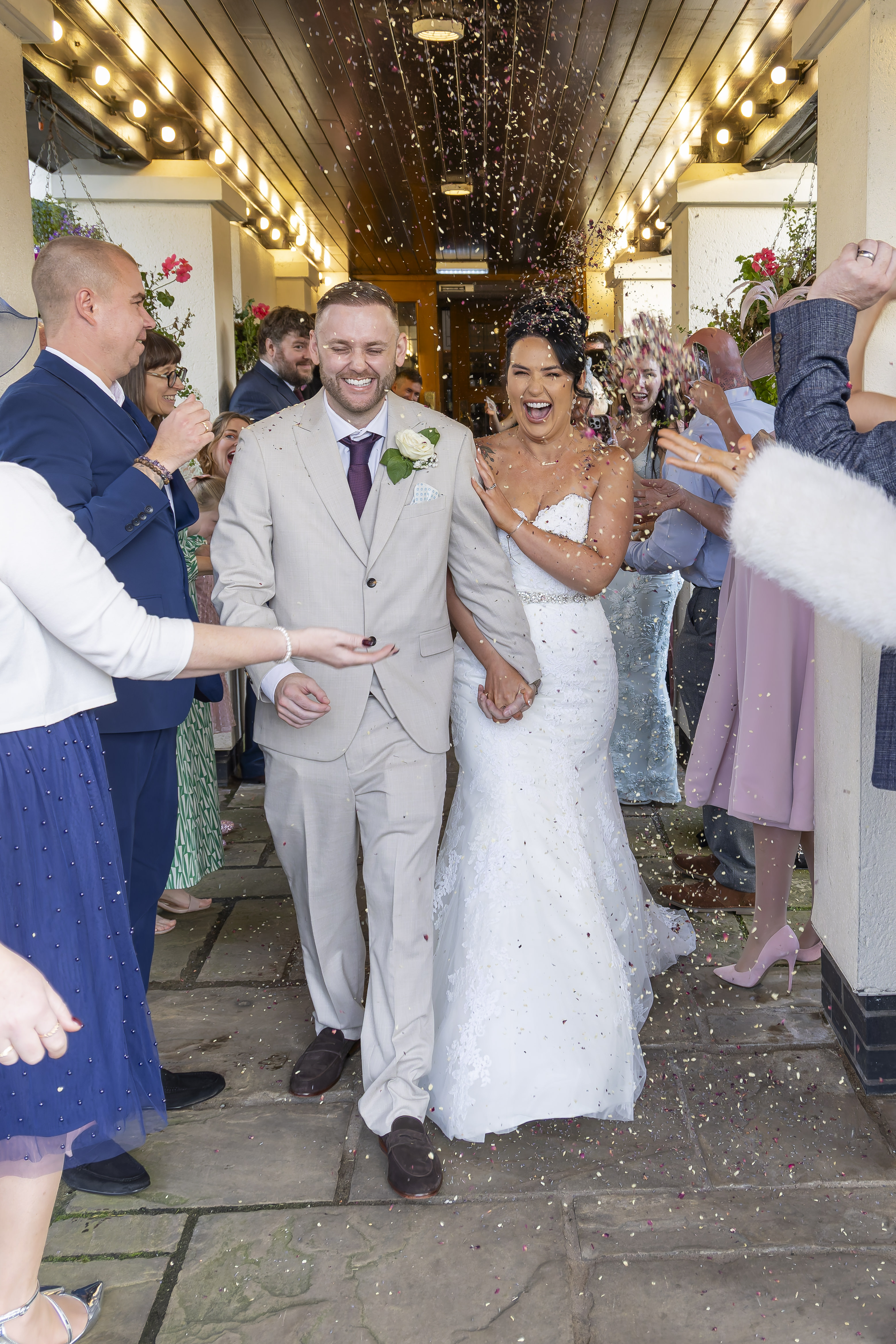 The wedding guests throw confetti at the bride and groom 