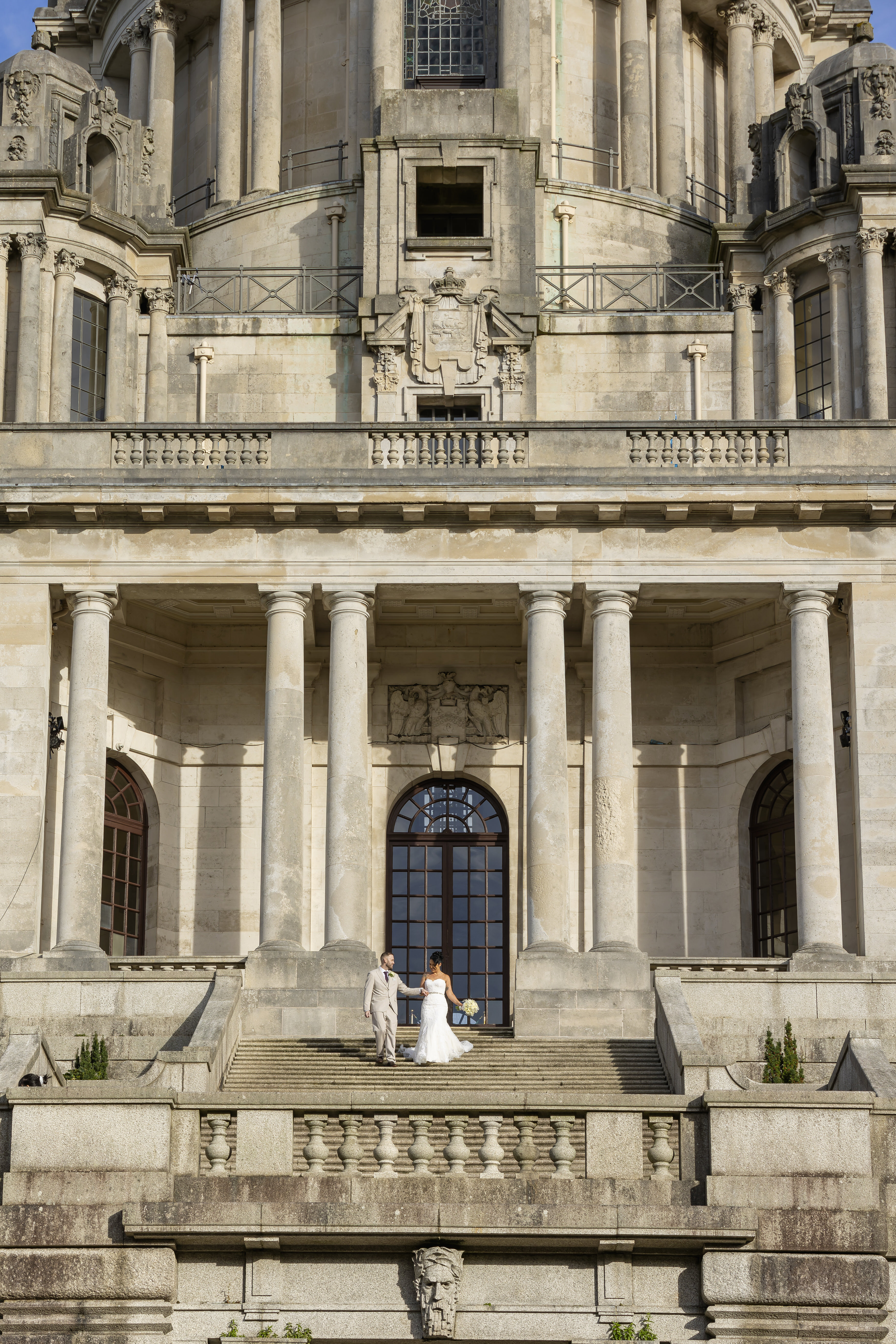 The bride and groom on the grand staircase at Ashton memorial 